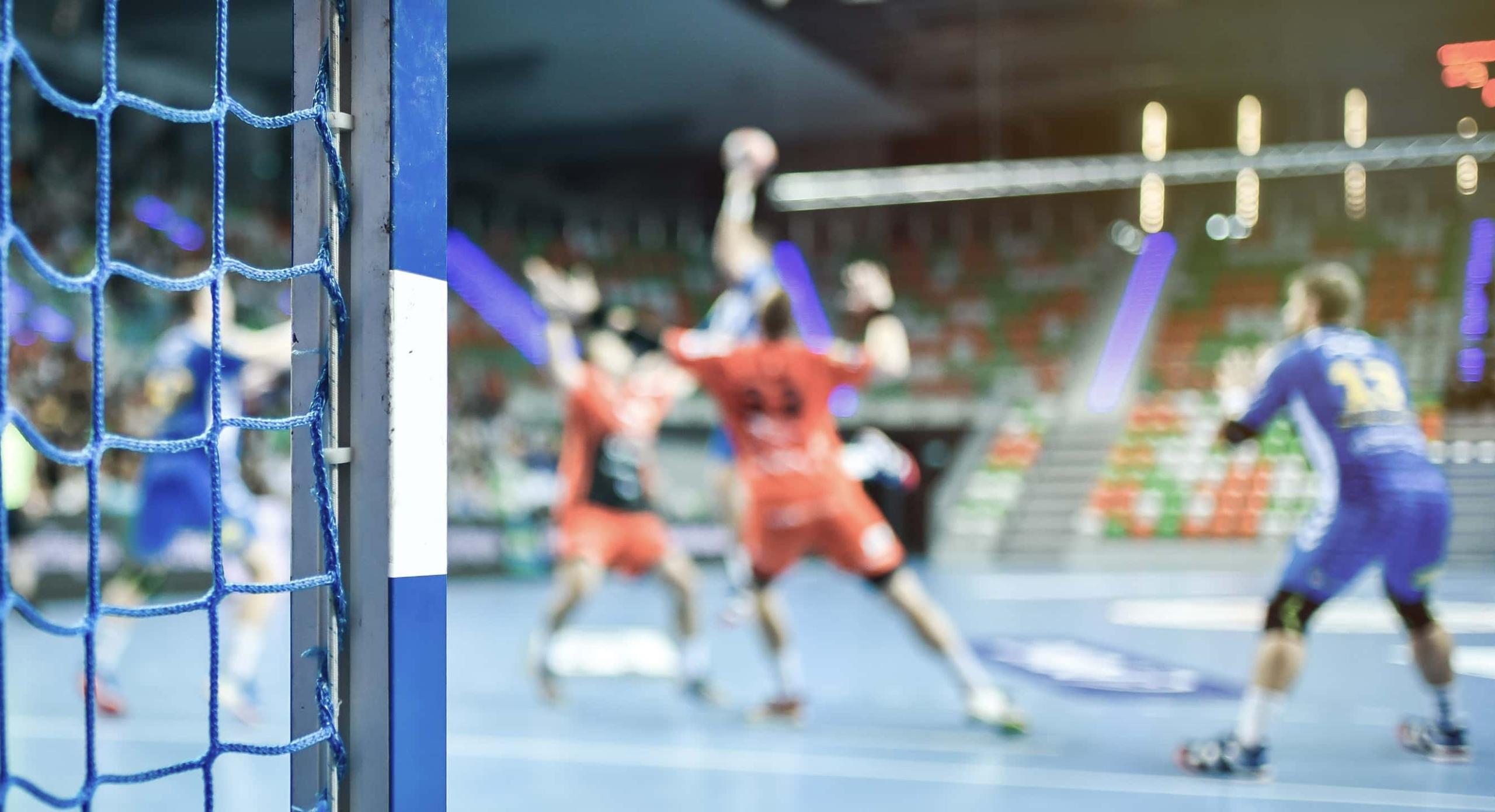 Eine Frau mit einem Handball auf dem Platz, bereit für das Spiel